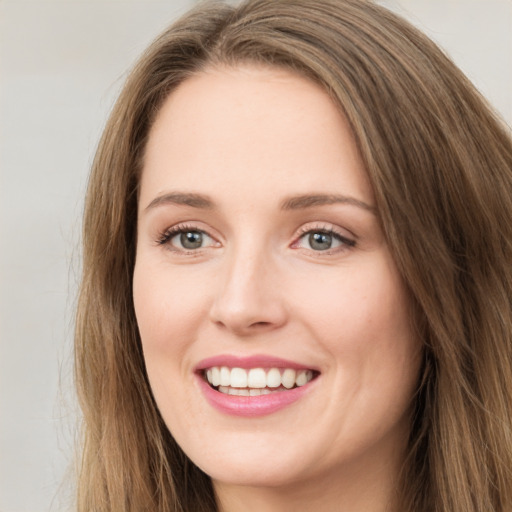 Joyful white young-adult female with long  brown hair and green eyes