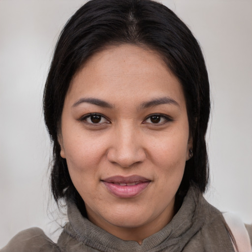 Joyful latino young-adult female with medium  brown hair and brown eyes