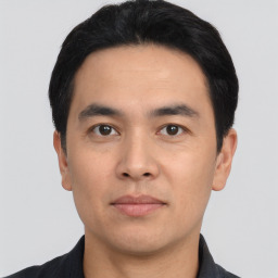 Joyful asian young-adult male with short  black hair and brown eyes