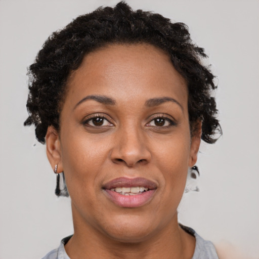 Joyful black adult female with short  brown hair and brown eyes