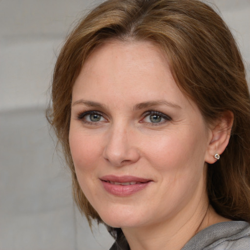 Joyful white adult female with medium  brown hair and blue eyes