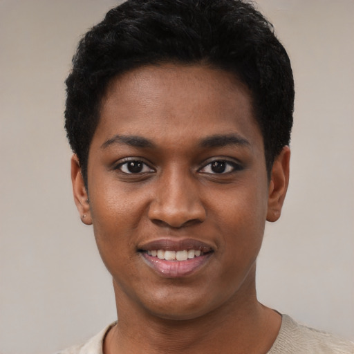 Joyful black young-adult female with short  black hair and brown eyes