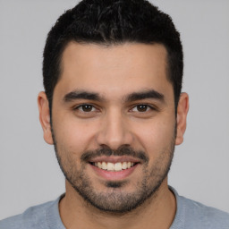 Joyful white young-adult male with short  black hair and brown eyes