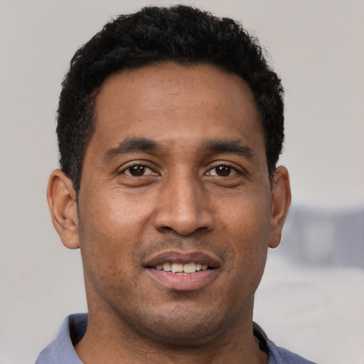 Joyful black young-adult male with short  black hair and brown eyes