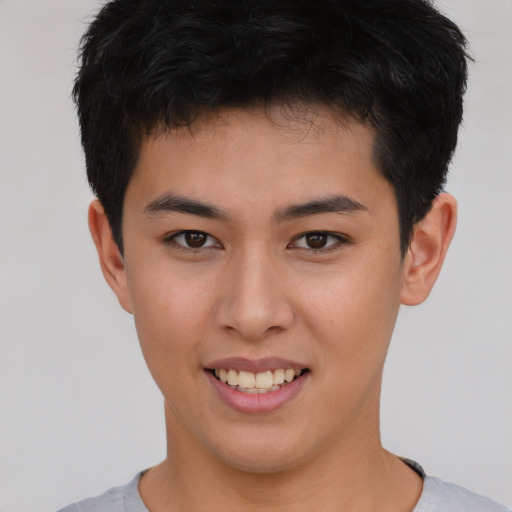 Joyful asian young-adult male with short  brown hair and brown eyes