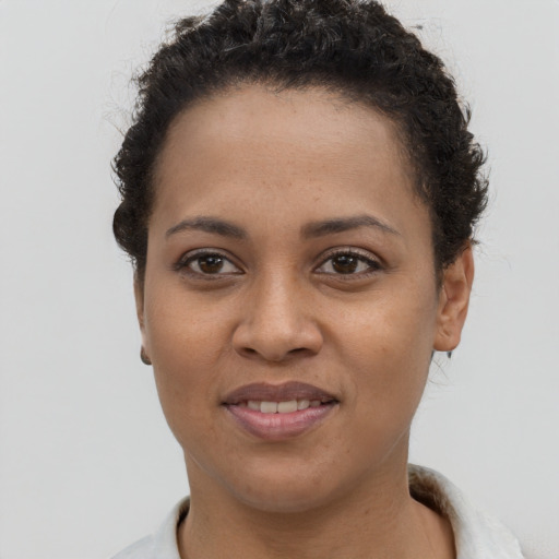 Joyful black young-adult female with short  brown hair and brown eyes