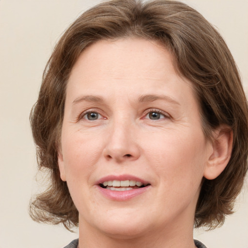 Joyful white adult female with medium  brown hair and grey eyes