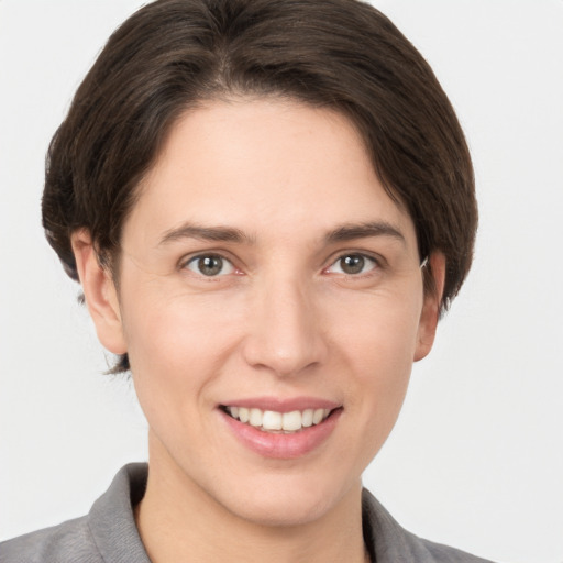 Joyful white young-adult female with medium  brown hair and grey eyes