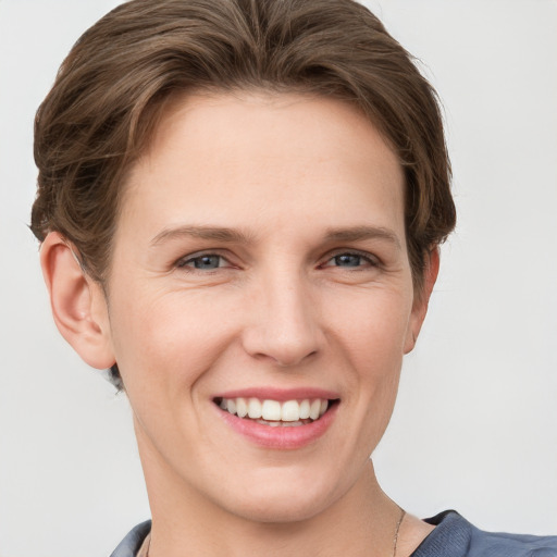 Joyful white young-adult female with short  brown hair and grey eyes