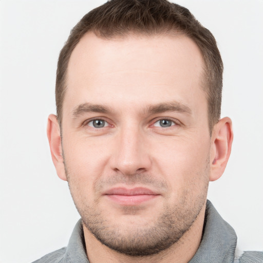 Joyful white young-adult male with short  brown hair and grey eyes