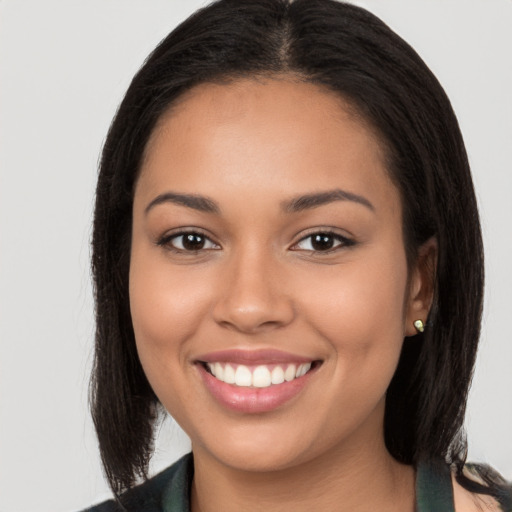 Joyful latino young-adult female with long  brown hair and brown eyes