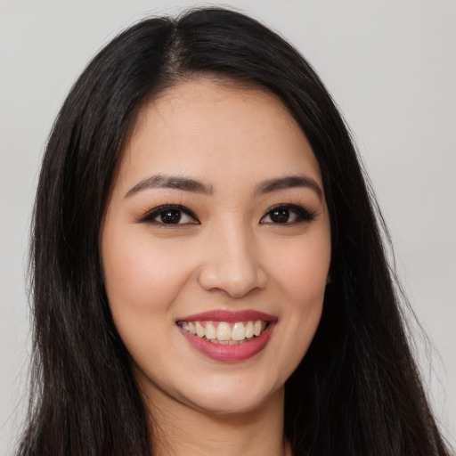 Joyful latino young-adult female with long  brown hair and brown eyes