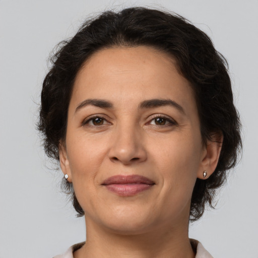 Joyful latino adult female with medium  brown hair and brown eyes