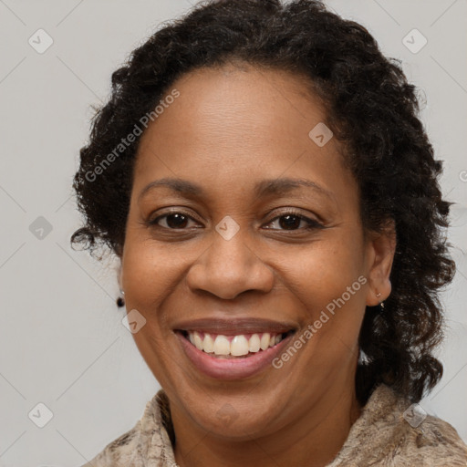 Joyful black adult female with long  brown hair and brown eyes