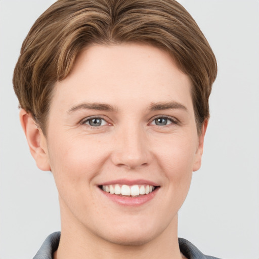 Joyful white young-adult female with short  brown hair and grey eyes