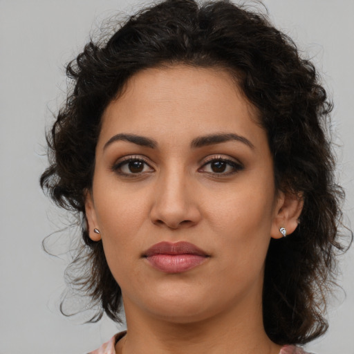 Joyful latino young-adult female with medium  brown hair and brown eyes