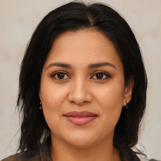 Joyful latino young-adult female with medium  brown hair and brown eyes