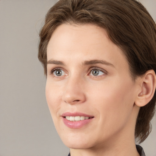 Joyful white young-adult female with medium  brown hair and grey eyes