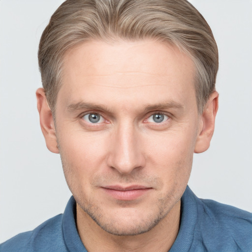 Joyful white adult male with short  brown hair and blue eyes