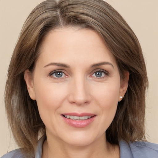 Joyful white adult female with medium  brown hair and grey eyes