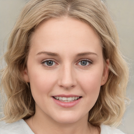 Joyful white young-adult female with medium  brown hair and blue eyes