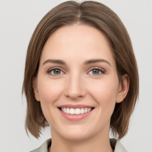 Joyful white young-adult female with medium  brown hair and green eyes