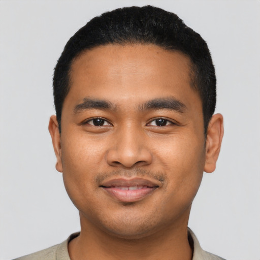 Joyful latino young-adult male with short  black hair and brown eyes