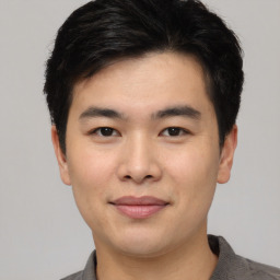 Joyful asian young-adult male with short  black hair and brown eyes