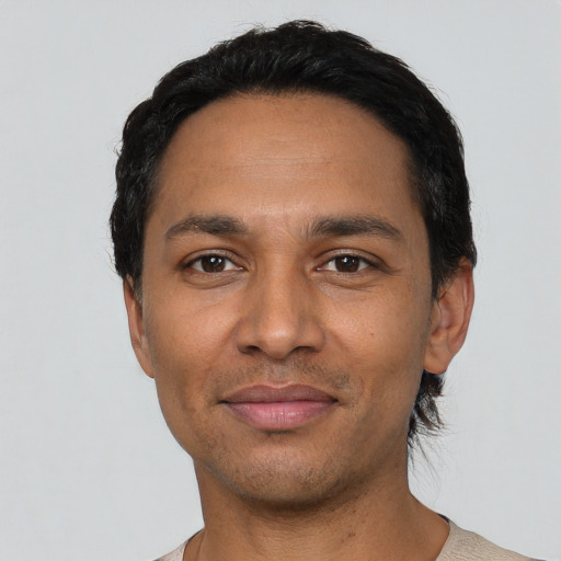 Joyful latino young-adult male with short  black hair and brown eyes