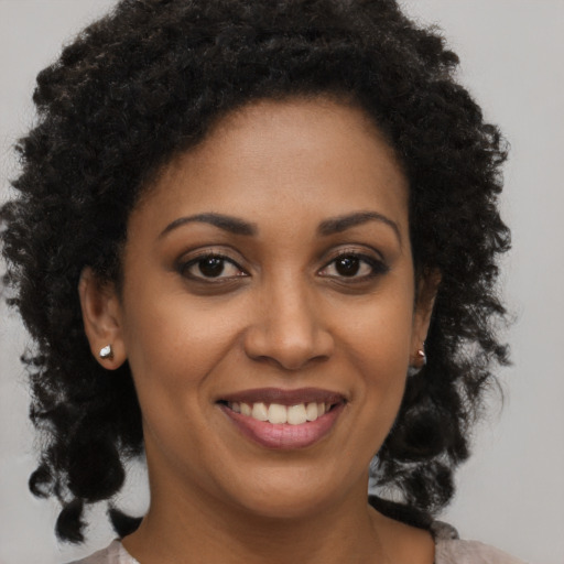 Joyful black young-adult female with medium  brown hair and brown eyes