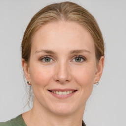 Joyful white young-adult female with medium  brown hair and grey eyes