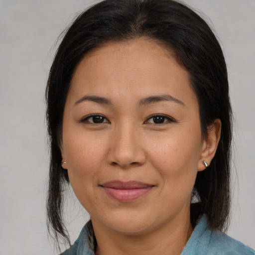 Joyful asian adult female with medium  brown hair and brown eyes