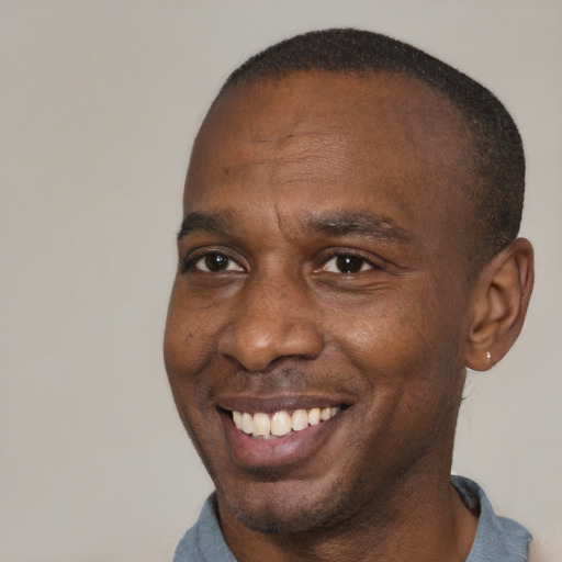 Joyful black adult male with short  brown hair and brown eyes