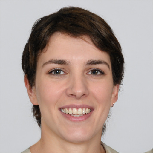 Joyful white young-adult female with medium  brown hair and green eyes