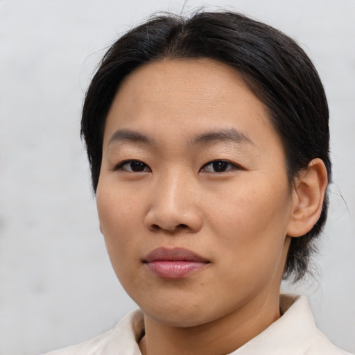 Joyful asian young-adult female with short  brown hair and brown eyes
