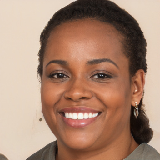 Joyful black young-adult female with long  brown hair and brown eyes