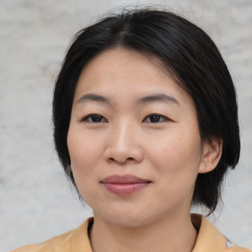 Joyful asian young-adult female with medium  black hair and brown eyes