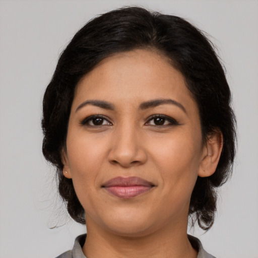 Joyful latino adult female with medium  brown hair and brown eyes