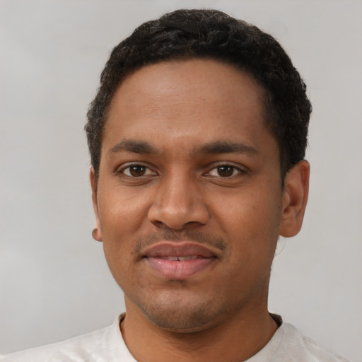 Joyful black young-adult male with short  black hair and brown eyes