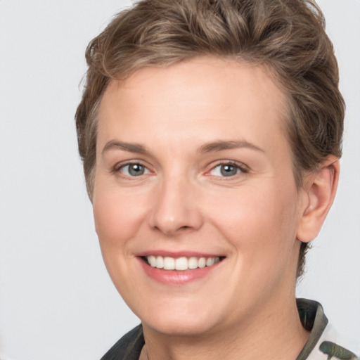 Joyful white young-adult female with short  brown hair and grey eyes