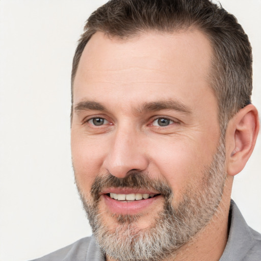 Joyful white adult male with short  brown hair and brown eyes