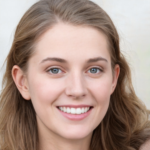 Joyful white young-adult female with long  brown hair and blue eyes