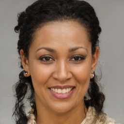 Joyful black young-adult female with long  brown hair and brown eyes