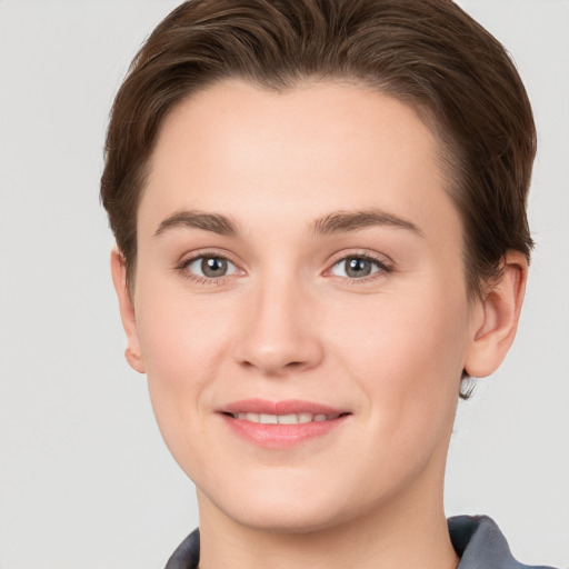 Joyful white young-adult female with short  brown hair and grey eyes