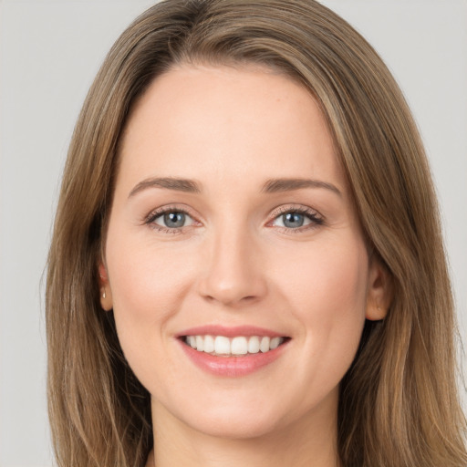 Joyful white young-adult female with long  brown hair and green eyes