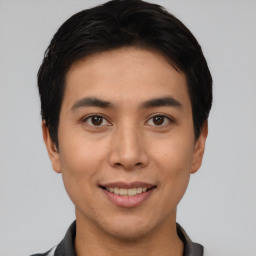 Joyful asian young-adult male with short  brown hair and brown eyes