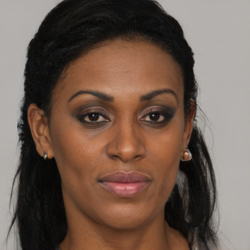 Joyful black adult female with long  brown hair and brown eyes