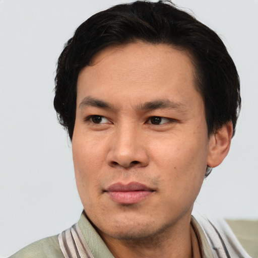 Joyful asian adult male with short  brown hair and brown eyes