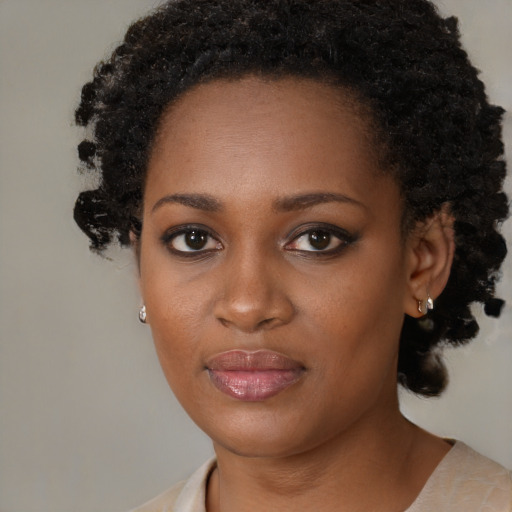 Joyful black young-adult female with short  black hair and brown eyes