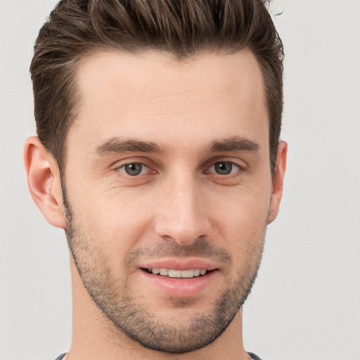 Joyful white young-adult male with short  brown hair and grey eyes